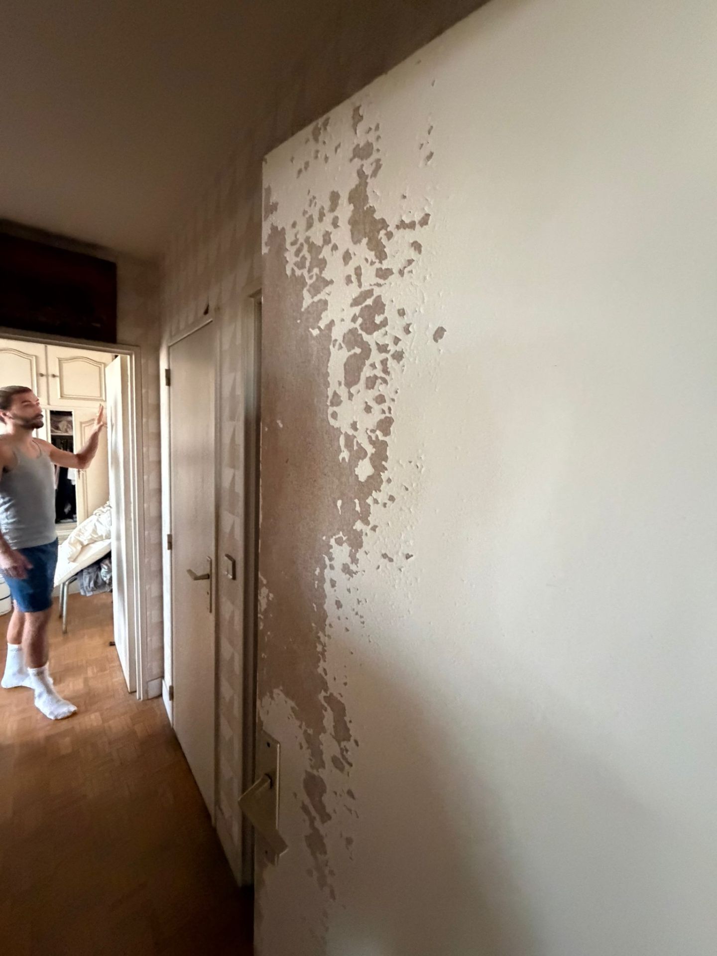 Couloir parisien avec peinture qui s'écaille avant rénovation